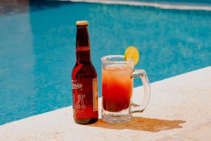 a bottle of beer and a glass with a drink at Hotel Plaza Colonial in Campeche