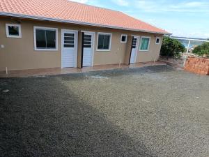 a house with a parking lot in front of it at Pousada Paraiso in Telêmaco Borba