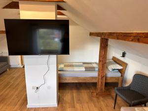 a room with a tv on a stand with a bed at Gästezimmer Kalletal in Kalletal