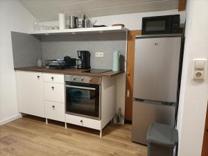 a small kitchen with a stove and a refrigerator at Gästezimmer Kalletal in Kalletal