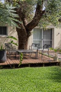 a wooden deck with benches and a tree at Los robles in San Pedro +11 photos