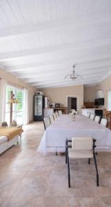 a dining room with a large white table and chairs at Los robles in San Pedro