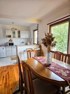 a kitchen and dining room with a table with a vase at Apartmani NINA Zlatar in Nova Varoš