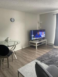 a living room with a tv and a table at Ron's Place in Saskatoon