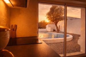 a kitchen with a view of a pool through a window at Cantinho do frade in Alandroal
