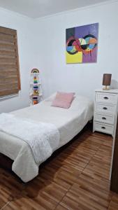 a bedroom with a bed and a dresser with a lamp at Casa Azul in Coñaripe