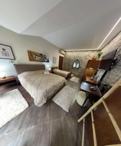 a bedroom with a large bed and a stone wall at Quinta dos Amores in Ponte de Lima