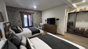 a hotel room with two beds and a television at Anae en ValQuirico in Santeagueda