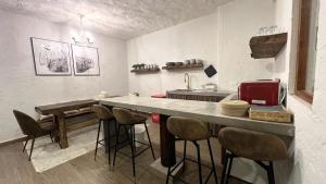 a kitchen with a counter and stools in a room at Anae en ValQuirico in Santeagueda