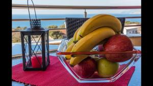 a bowl of fruit on a table with apples and bananas at Apartmani Minna Alim in Utjeha