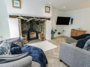 a living room with two couches and a fireplace at Rhows in Llanfairpwllgwyngyll