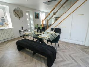 a dining room with a glass table and black chairs at Rhows in Llanfairpwllgwyngyll +16 photos
