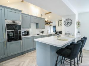 a kitchen with blue cabinets and a white counter top at Rhows in Llanfairpwllgwyngyll