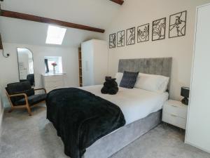a bedroom with a bed with a teddy bear sitting on it at Rhows in Llanfairpwllgwyngyll