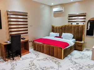 a bedroom with a bed and a desk and a computer at Servy Hotels in Port Harcourt