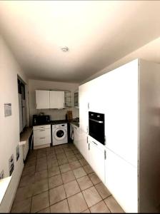 a small kitchen with white cabinets and a dishwasher at BH Haus in Bremerhaven