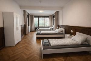 two beds in a room with wooden floors at BH Haus in Bremerhaven