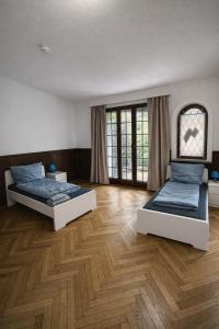 two beds in a large room with wooden floors at BH Haus in Bremerhaven +7 photos