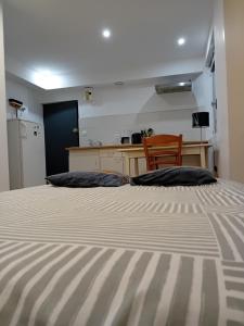 a bedroom with a large bed with a desk and a chair at Chambre équipée in Languidic