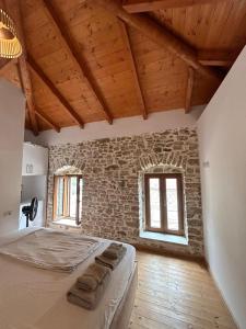 a bedroom with a large bed in a brick wall at Vila, Upper Qeparo in Qeparoi i Sipërm
