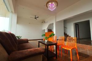 a living room with a couch and chairs and a table at Fairy Beach House - DK Resort in Pondicherry