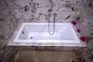a white bath tub in a marble bathroom at Fairy Beach House - DK Resort in Pondicherry +33 photos