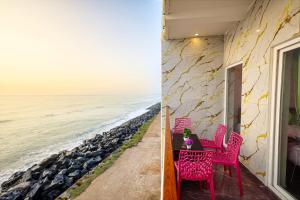 a room with a view of the ocean and a table and chairs at Fairy Beach House - DK Resort in Pondicherry