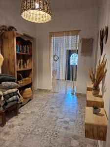 a living room with a large window and a chandelier at Home Maro in Lefkimmi