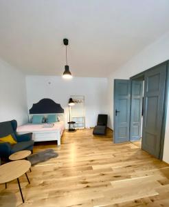 a living room with a bed and a wooden floor at Apartament Pod Tężnią in Głuchołazy