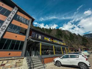 a white car parked in front of a building at Doga Motel in Uzungöl