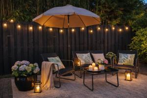 a patio with chairs and a table with an umbrella and candles at Bergen Delight in Bergen