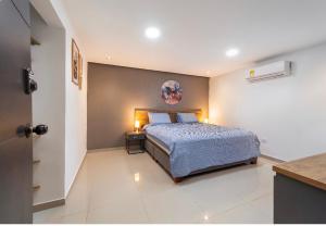 a bedroom with a bed and a table with two lamps at In Situ Hotel in Cali