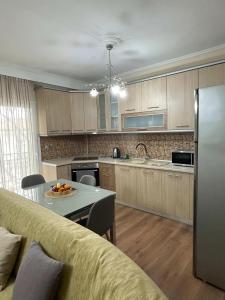 a kitchen with wooden cabinets and a table with a plate of fruit on it at ANATOLI Waterfalls Retreat in Edessa