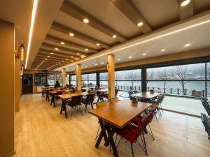 a restaurant with wooden tables and chairs and a large window at Doga Motel in Uzungöl