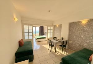a living room with a table and a dining room at Traumhaftes Studio mit Meerblick & Pool in Khlorakas +17 photos