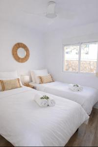 two beds in a room with white walls at Casa MuMa in Calpe +22 photos