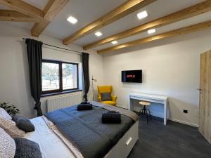 a bedroom with a bed and a desk and a television at Házikon 2 Apartman in Igricetanya