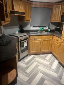 a kitchen with wooden cabinets and a wooden floor at Millfields caravan park I9 in Skegness