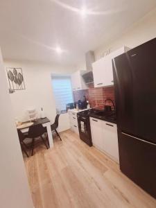 eine Küche mit einem schwarzen Kühlschrank und einem Tisch in der Unterkunft Domi studio in Chełmno