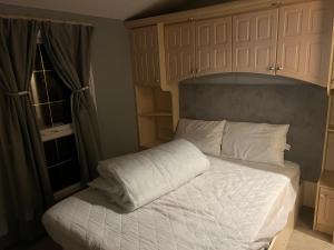 a bed with white sheets and pillows in a bedroom at Millfields caravan park I9 in Skegness