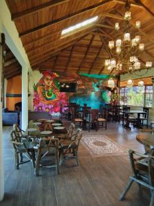 a dining room with a large painting on the wall at Las Orquídeas Runtun Lodge in Baños +72 photos