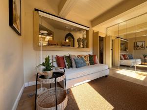 a living room with a couch and a mirror at La Casetta di Borgo - Gli Ulivi in Lajatico