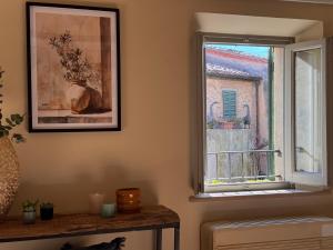 a window in a living room with a picture on the wall at La Casetta di Borgo - Gli Ulivi in Lajatico