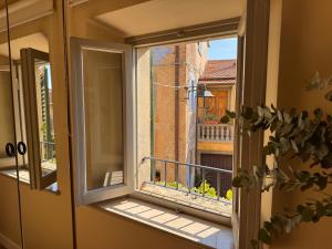 an open window with a view of a balcony at La Casetta di Borgo - Gli Ulivi in Lajatico +29 photos
