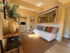 a living room with a couch and a mirror at La Casetta di Borgo - Gli Ulivi in Lajatico