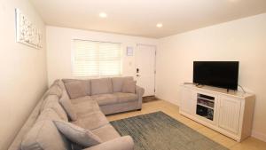 a living room with a couch and a flat screen tv at Broadway Beach Retreat Unit 4 in Cape May
