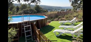 two white chairs and a swimming pool in a yard at El Balcón del Rey in Ruidera