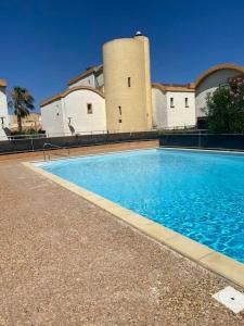 a large swimming pool in front of a building at Pause Soleil in Gruissan