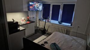 a hospital room with a bed and a tv at RentA Citywalk Flat in Kaunas