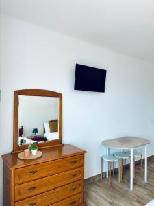 a dresser with a mirror and a table with two stools at Seaside & Levada Escape in Machico